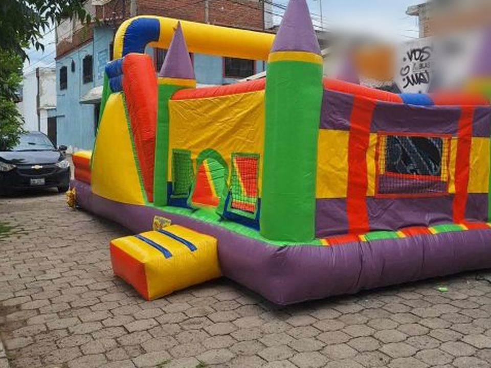 Castillo inflable con torres de colores y rampa amarilla de Diversiones Papus